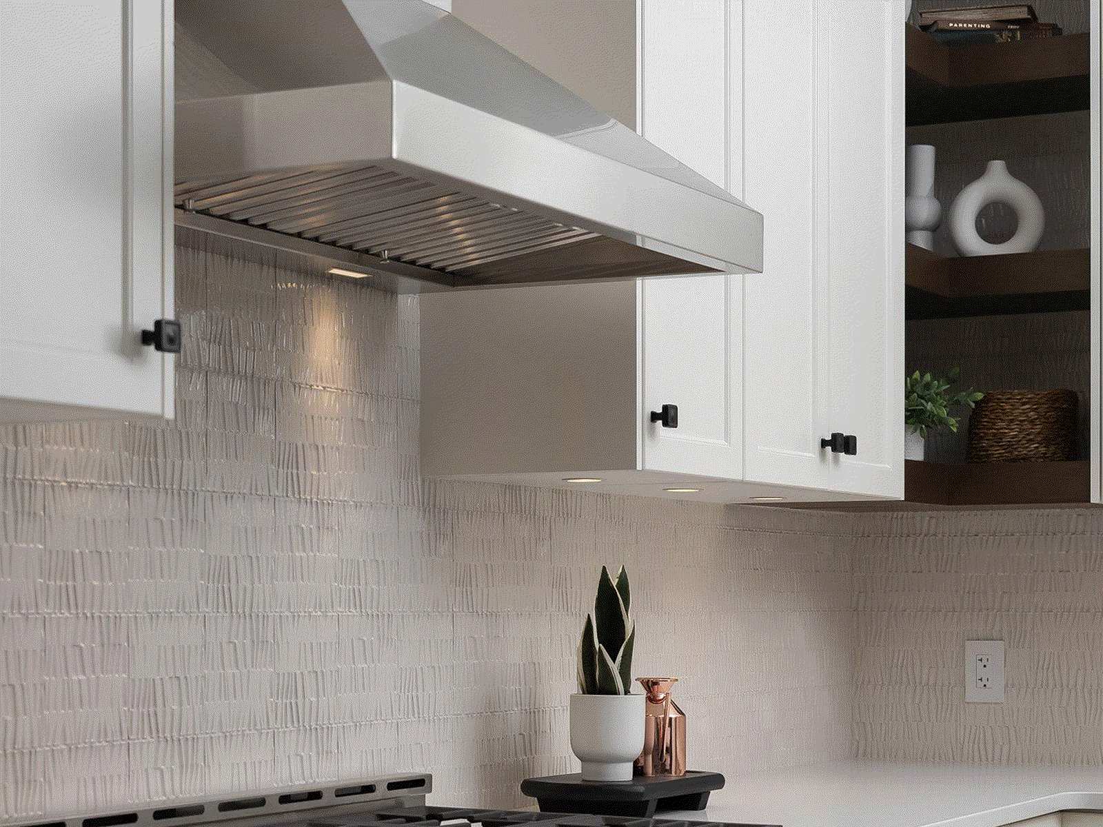 Modern stainless steel wall-mount quiet range hoods with high-efficiency baffle filters installed in a contemporary white kitchen