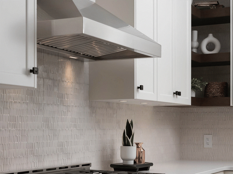 Victory Twister wall mount range hood installed in a modern kitchen with white cabinets and professional LED lighting