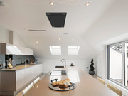 Matte Black Victory Sunset ceiling mount range hood installed in a modern white kitchen island ceiling for an open-concept view