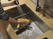 Fresh produce being rinsed in a high-capacity 16-gauge stainless steel basin, highlighting the expansive workspace for food preparation.